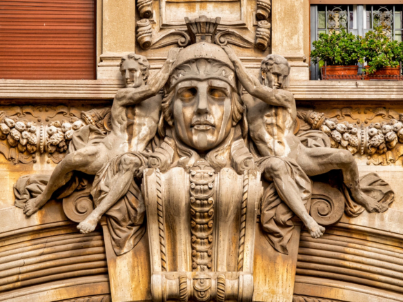 Dettaglio scultoreo del Quartiere Coppedè a Roma con figure classiche e volto monumentale