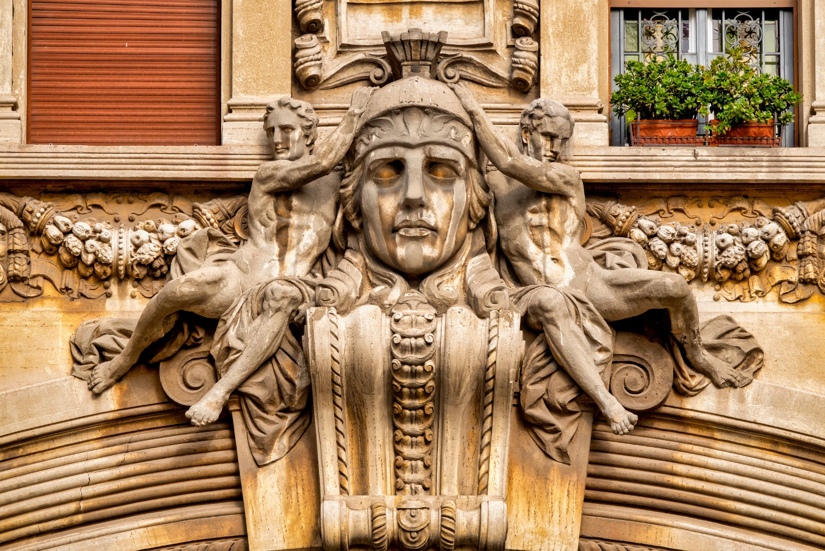Dettaglio scultoreo del Quartiere Coppedè a Roma con figure classiche e volto monumentale